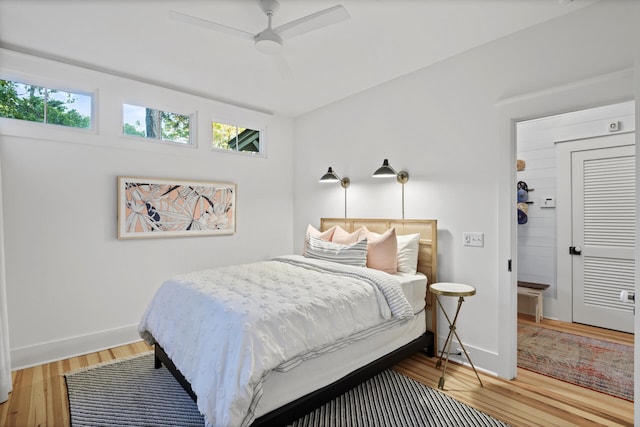 bedroom with light hardwood / wood-style flooring, ceiling fan, and a closet