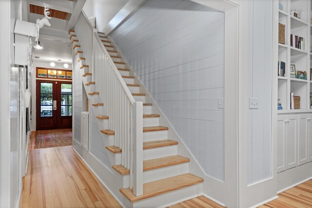 stairs featuring french doors and light hardwood / wood-style flooring