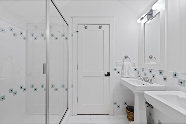 bathroom featuring backsplash, a shower with door, tile floors, and tile walls