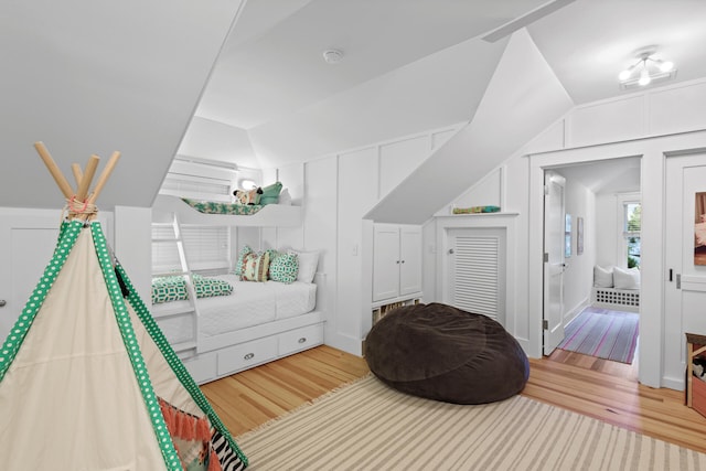 bedroom featuring light hardwood / wood-style flooring and lofted ceiling