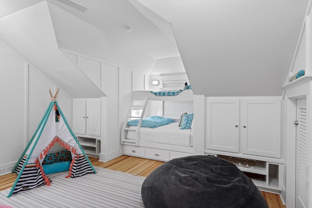 bedroom with light hardwood / wood-style floors and vaulted ceiling