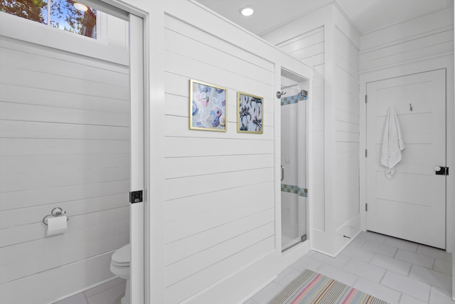 bathroom featuring tile flooring, wood walls, an enclosed shower, and toilet