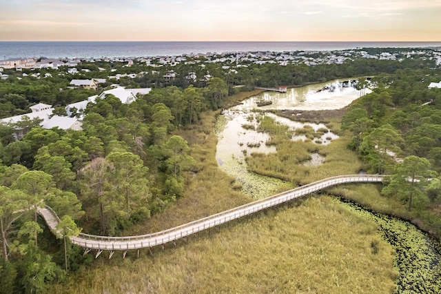 aerial view at dusk featuring a water view