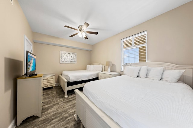 bedroom with dark hardwood / wood-style flooring and ceiling fan