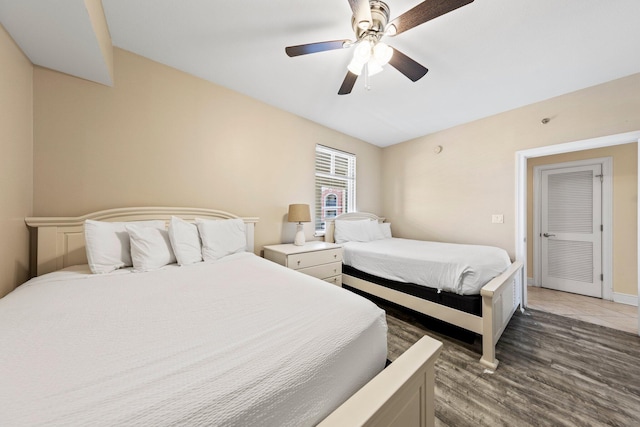 bedroom with dark hardwood / wood-style flooring and ceiling fan