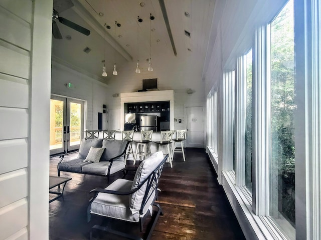 living room with dark hardwood / wood-style floors, french doors, a healthy amount of sunlight, and a high ceiling