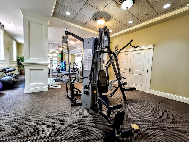 gym with a paneled ceiling and ornamental molding