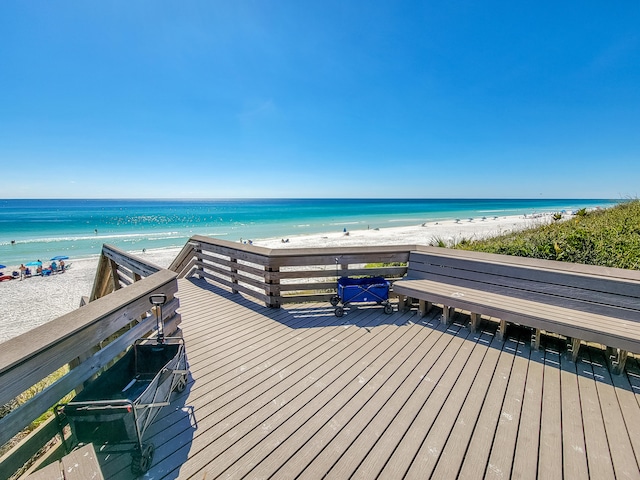 view of dock with a beach view and a water view