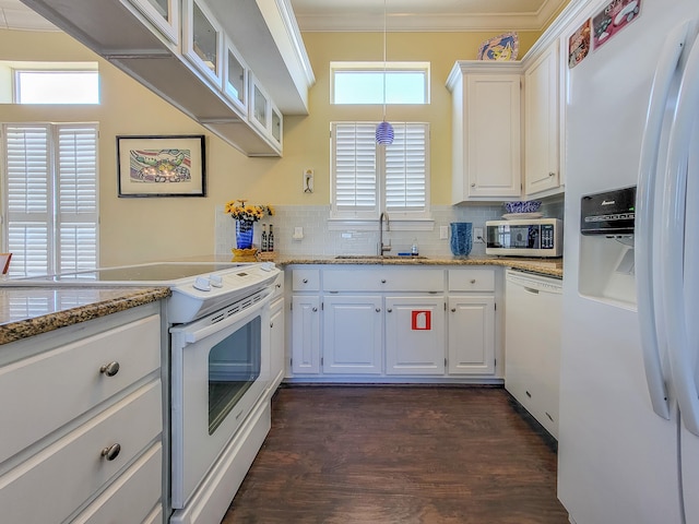 kitchen featuring decorative light fixtures, white cabinets, white appliances, dark hardwood / wood-style floors, and sink