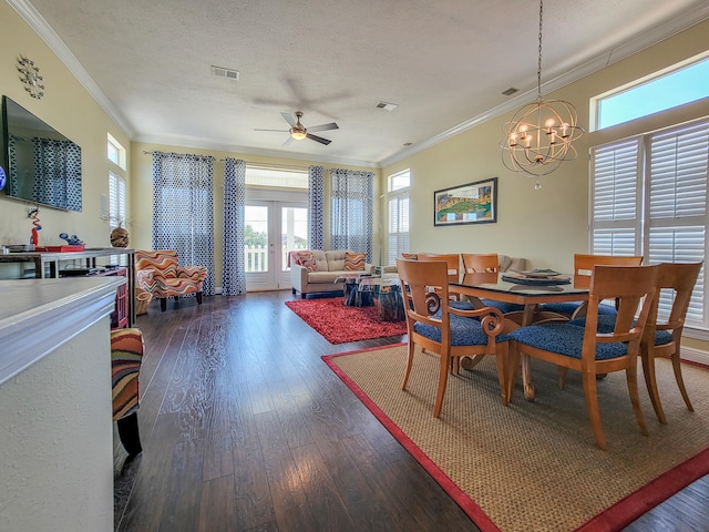 dining space featuring ceiling fan with notable chandelier, crown molding, dark wood-type flooring, and a textured ceiling