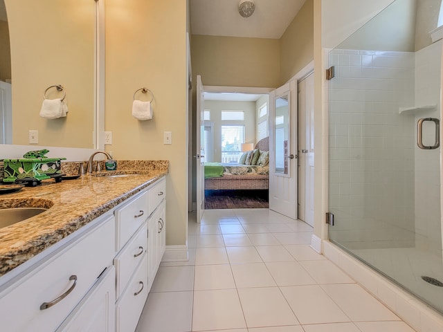 bathroom featuring a shower with door, tile floors, and dual vanity