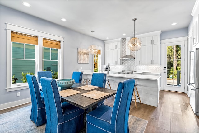 dining space with an inviting chandelier and light hardwood / wood-style flooring