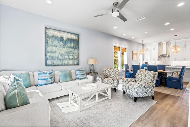 living room featuring light hardwood / wood-style flooring and ceiling fan