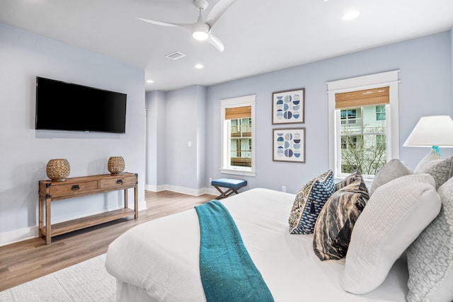 bedroom with multiple windows, ceiling fan, and light hardwood / wood-style flooring