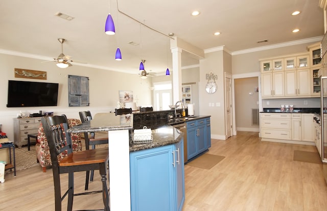 kitchen featuring blue cabinetry, ceiling fan, dark stone counters, pendant lighting, and light wood-type flooring