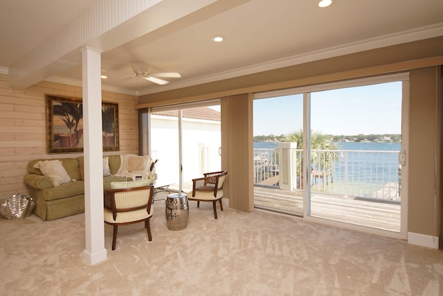 living area featuring light carpet, beam ceiling, crown molding, and ceiling fan