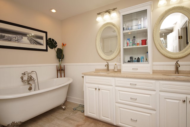 bathroom with a tub, dual bowl vanity, and hardwood / wood-style flooring