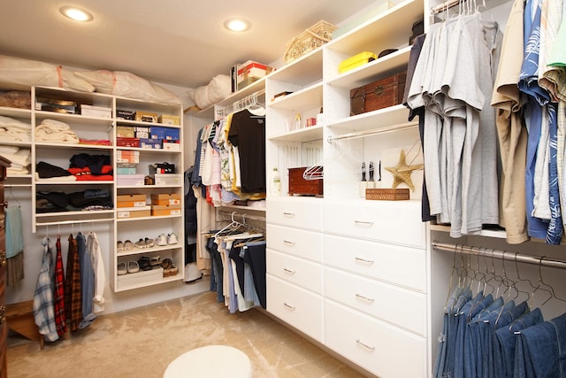 walk in closet featuring light colored carpet