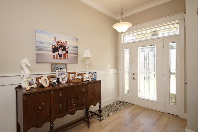 foyer with light hardwood / wood-style floors and crown molding