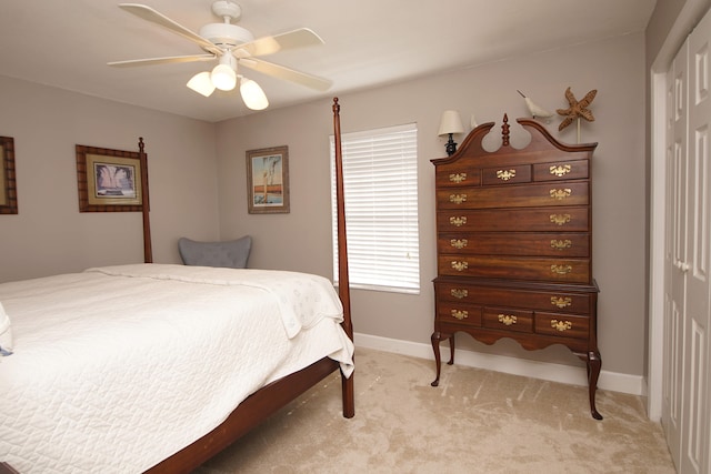 bedroom with a closet, light carpet, and ceiling fan