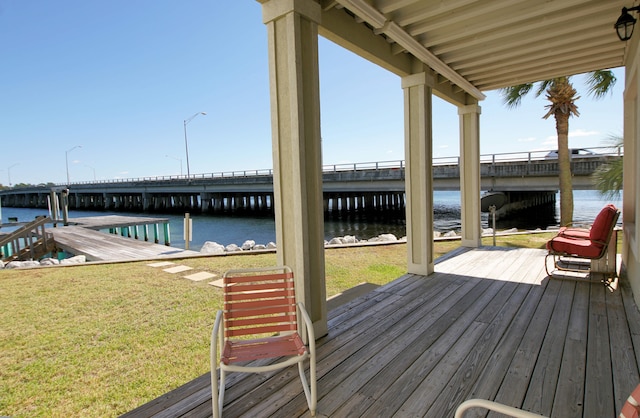 wooden deck featuring a water view, a yard, and a dock