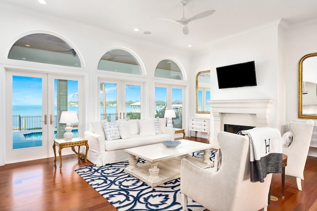 living room featuring a water view, crown molding, ceiling fan, dark hardwood / wood-style floors, and french doors