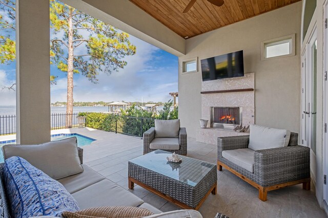 view of patio / terrace with an outdoor living space with a fireplace and a water view