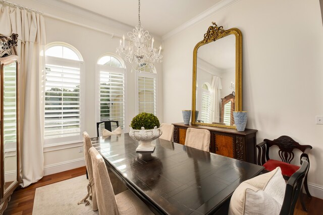 dining space with a notable chandelier, dark hardwood / wood-style floors, and crown molding