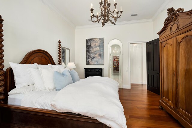 bedroom featuring ornamental molding, dark wood-type flooring, and a chandelier