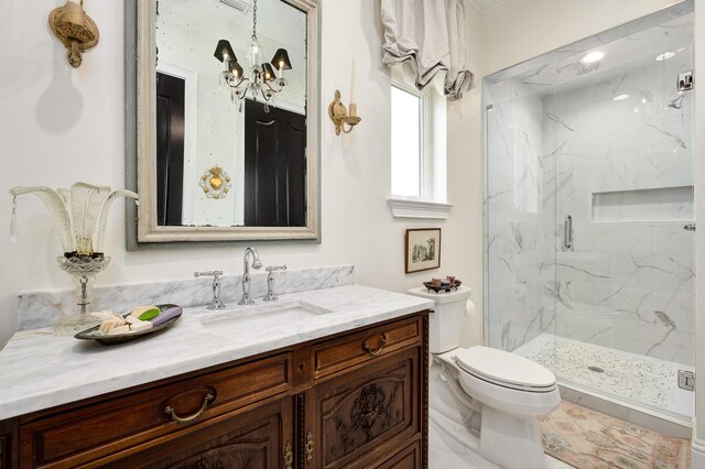 bathroom featuring vanity, toilet, an inviting chandelier, and walk in shower