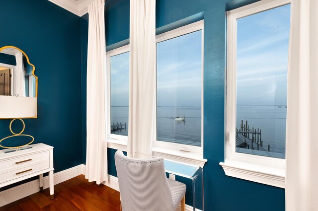 office space with crown molding, dark wood-type flooring, and a water view