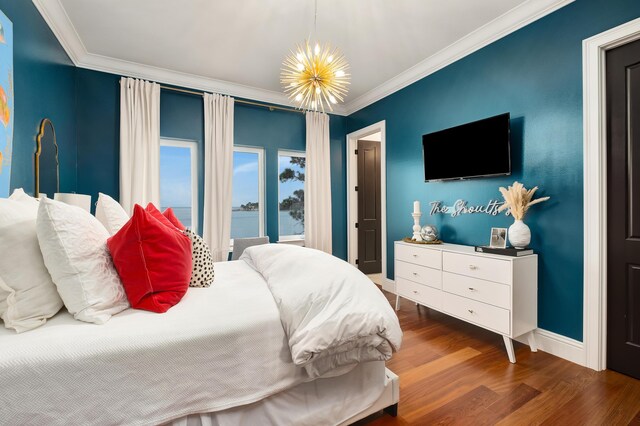 bedroom with dark hardwood / wood-style floors, a notable chandelier, and ornamental molding