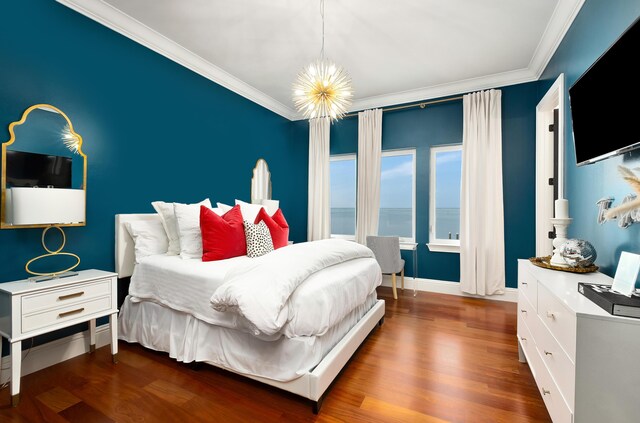 bedroom featuring a water view, dark hardwood / wood-style floors, a notable chandelier, and ornamental molding