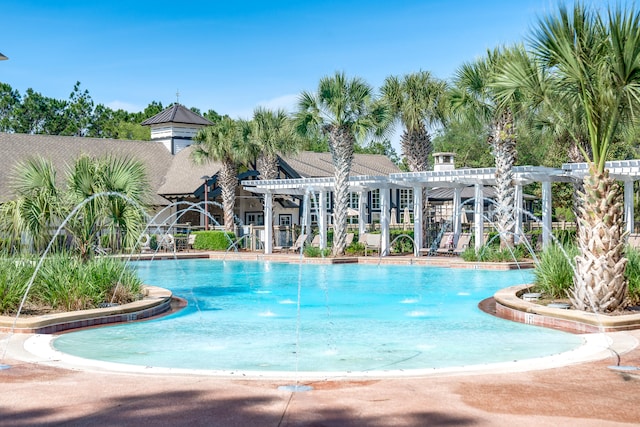 view of pool with a pergola and pool water feature