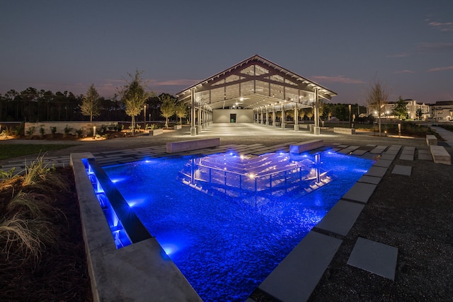 pool at dusk with pool water feature