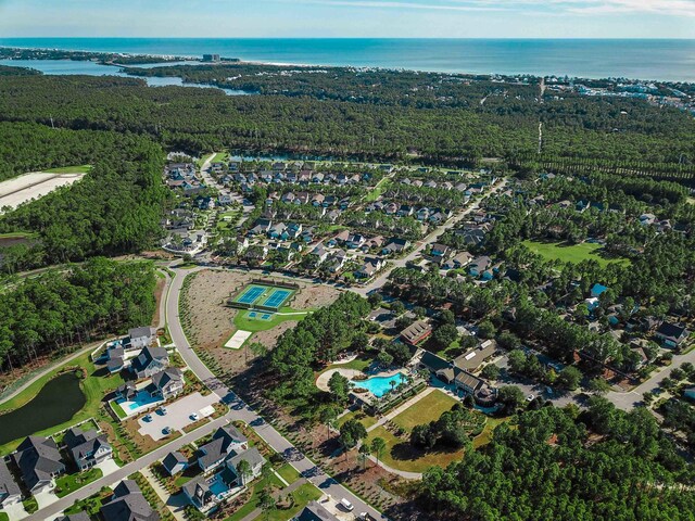 drone / aerial view with a water view and a wooded view