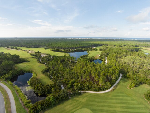 aerial view featuring a water view, view of golf course, and a view of trees