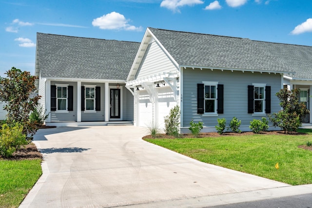 view of front of home with a garage, a front yard, and a porch