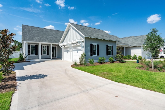 single story home with a front lawn, roof with shingles, driveway, and an attached garage