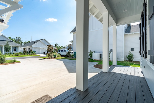 wooden deck with a residential view and concrete driveway