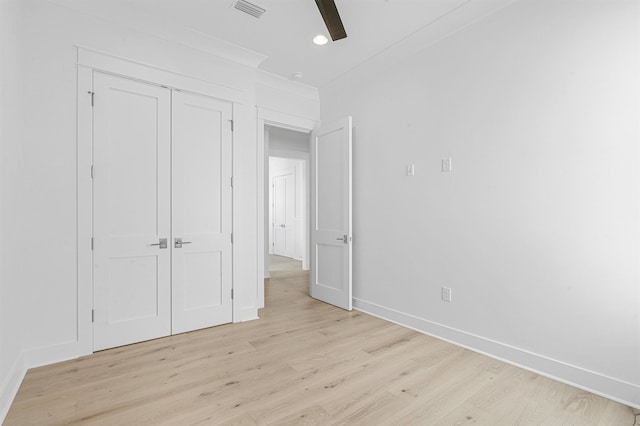 unfurnished bedroom with a closet, visible vents, a ceiling fan, light wood-type flooring, and baseboards