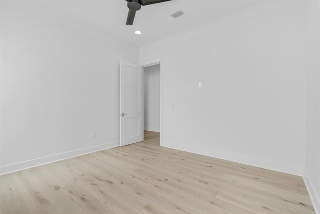 spare room with ceiling fan, light wood-type flooring, visible vents, and baseboards