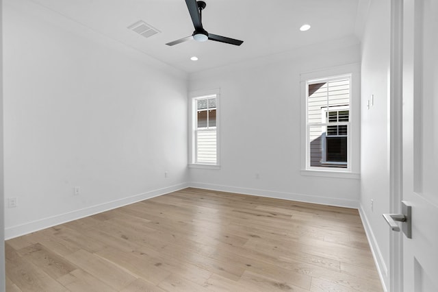 empty room featuring light wood-style flooring, visible vents, and baseboards