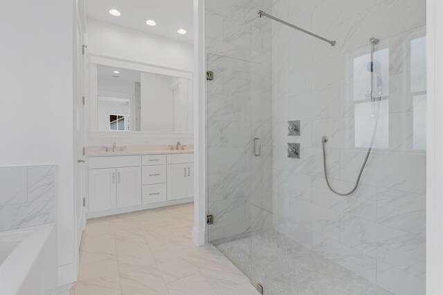 bathroom with a sink, marble finish floor, a marble finish shower, a bath, and double vanity