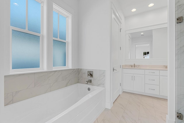 full bathroom with marble finish floor, a garden tub, double vanity, recessed lighting, and a sink