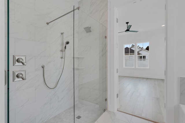 full bathroom featuring ceiling fan, a shower stall, and baseboards