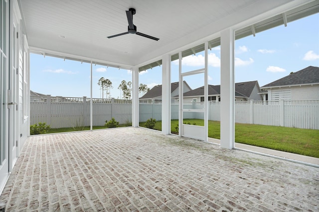 unfurnished sunroom with a ceiling fan