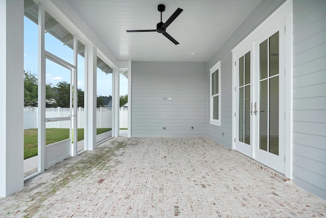 unfurnished sunroom with a ceiling fan