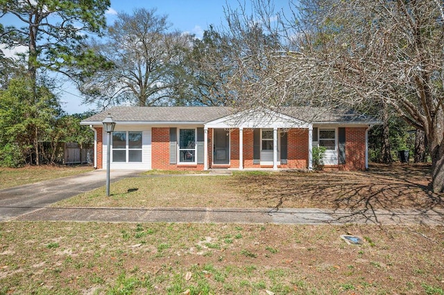 ranch-style home with brick siding, aphalt driveway, a front lawn, and fence