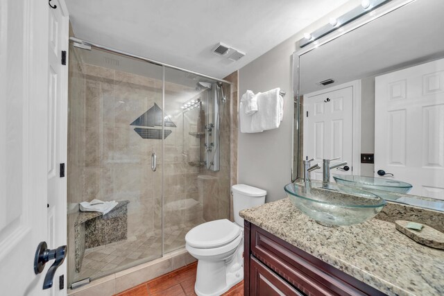 bathroom featuring an enclosed shower, vanity, toilet, and tile flooring